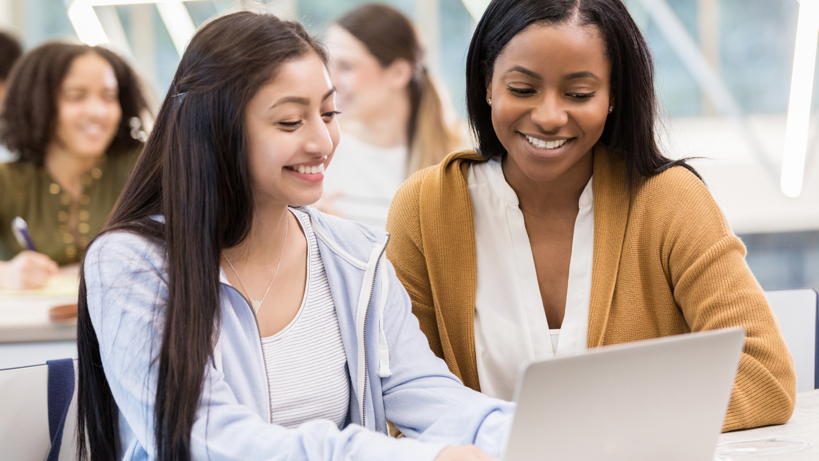 Girl student on computer with help from teacher Girl student on computer with help from teacher